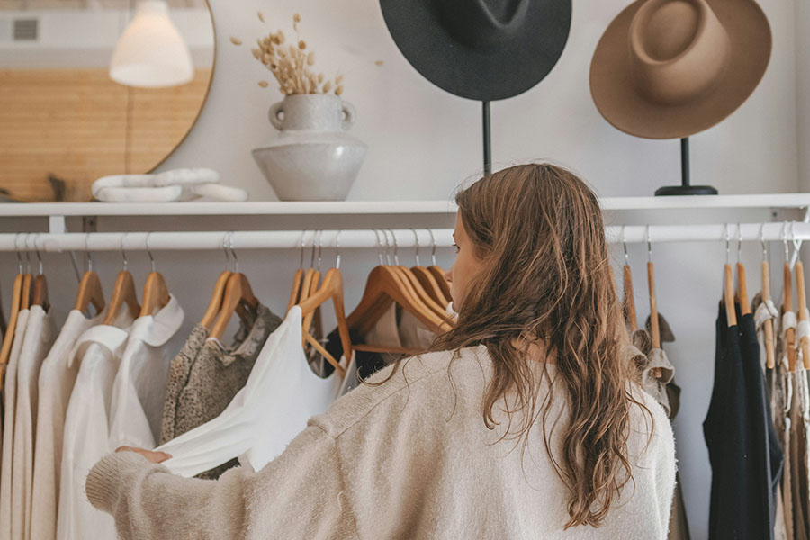 Person looking through clothes on rack at trendy boutique.